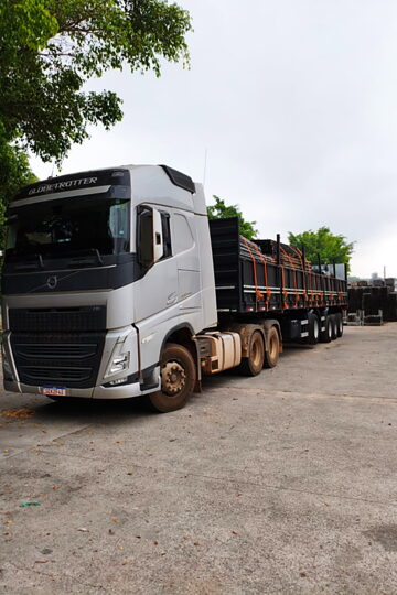 Cavalo mecânico engatado à carreta carregada, estacionado no pátio antes da saída.